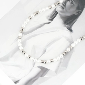 Minimalist titanium steel pearl necklace with alternating silver beads on a fashion magazine
