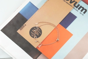 Détails des breloques étoile et cœur en or rose sur chaîne O sur magazine design