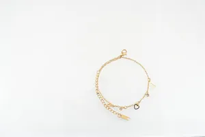Détail du bracelet en acier titane doré avec breloques d'étoiles et de Tour Eiffel