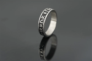 Macro shot of vintage Viking runes engraved on a polished silver titanium steel ring