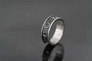Macro view of vintage titanium steel ring with moon phase and star relief patterns