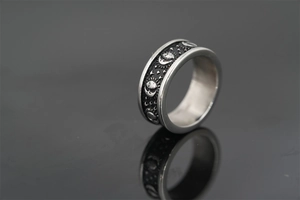 Detail of vintage silver titanium steel ring with sun moon and star relief carving