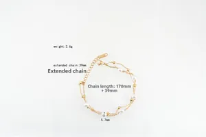 Détail du bracelet double chaîne dorée avec perles et fermoir mousqueton réglable
