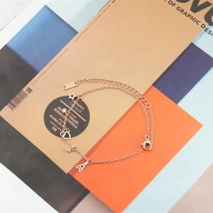 Bracelet double couche en or rose avec breloques étoile et cœur sur fond de magazine