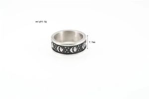 Detail of 7.7mm wide titanium steel ring with celestial sun moon and star engravings