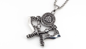 Macro detail of Nordic Viking double axe pendant with Valknut symbol and rune engraving