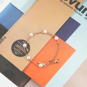 Bracelet élégant à double chaîne dorée avec perles blanches et fermoir mousqueton ajustable