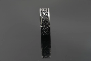 Makroaufnahme eines Vintage-Rings aus Titanstahl mit geprägtem Pilzmuster-Design