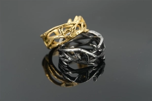 Macro shot of thorn vine style titanium rings in polished gold and antique silver finish