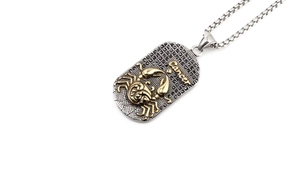 Détail du pendentif zodiaque Cancer avec pierres noires et crabe doré en relief sur chaîne