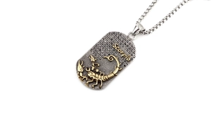 Détail du pendentif Scorpion avec relief doré et strass noirs sur chaîne punk chic