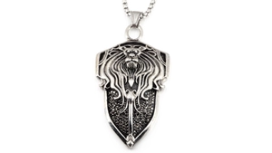 Macro detail of vintage lion head shield pendant with black stone inlay and silver finish