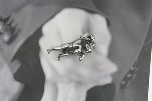 Detailed view of a vintage silver bull pendant with intricate 3D muscular carving detail