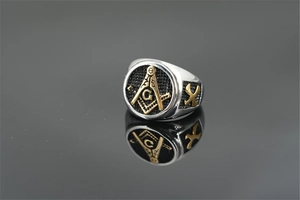 Macro shot of gold and silver dual-tone Freemason ring with polished compass and G symbol