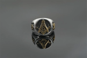 Macro detail of Freemasonry signet ring with gold square and compass symbol on silver steel
