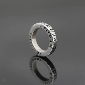 Bague minimaliste en acier argenté avec gravure Freedom et Independent et son reflet