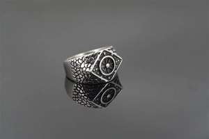 Macro shot of punk style hexagonal ring with engraved ship wheel and textured metal details