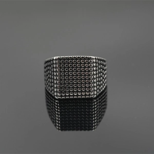 Punk style men's stainless steel ring with textured dot pattern on black reflective surface