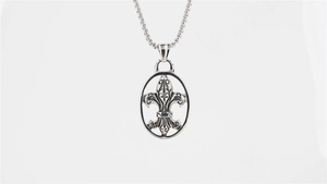 Macro detail of retro fleur-de-lis oval pendant with vintage silver finish and texture