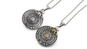 Nahaufnahme von ethnischen Drachen- und Bagua-Anhängern in Silber und Goldoptik