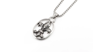 Detailed macro shot of vintage fleur-de-lis pendant with box chain in titanium steel