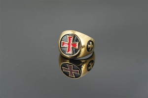 Makroaufnahme eines goldenen Siegelrings mit rotem Emaille-Kreuzdetail aus Edelstahl