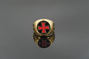 Makroaufnahme des goldenen Kreuzrings mit rotem Malteserkreuz auf schwarzer Emaille