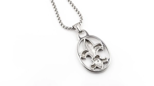 Macro detail of silver fleur-de-lis oval pendant with a sturdy box chain necklace