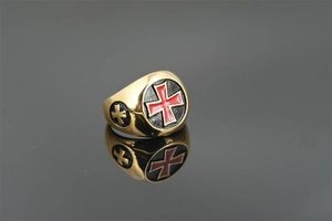 Nahaufnahme eines Vintage-Punk-Siegelrings mit rotem Kreuz auf schwarzem Hintergrund