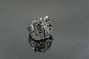 Close-up of vintage Gothic cross ring with textured details and silver finish