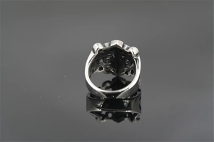 Macro detail of vintage gothic cross ring with intricate hollow engraving and silver finish