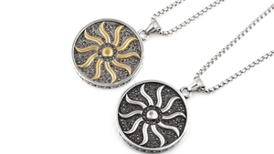 Dettaglio macro del ciondolo totem sole retrò in argento e oro con trame sofisticate