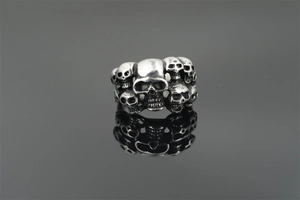 Macro detail of punk skull ring featuring intricate relief carvings and mirror reflection