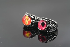 Detailed view of punk rings featuring dragon claws holding yellow and red evil eye stones