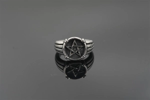 Macro shot of silver titanium steel ring with a 3D star and vintage polished details