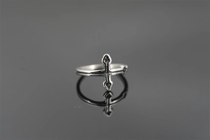 Detailed view of vintage silver cross ring with punk style oxidized finish and engravings