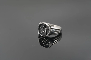 Macro shot of retro stainless steel ring with 3D star crest and oxidized finish