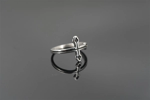 Macro detail of vintage punk cross ring in silver finish with retro oxidized texture