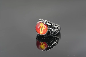 Macro detail of punk rock serpent ring featuring a red dragon eye and steel scales