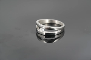 Close-up of double-layered silver ring featuring a sparkling central zircon on a dark surface