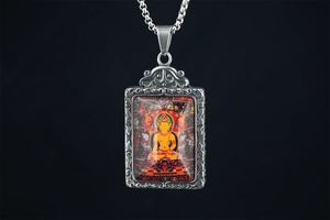 Detailed view of silver Tibetan Thangka Buddha pendant with ornate steel frame