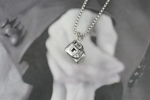 Macro shot of retro camera pendant necklace in oxidized S925 silver on art photo