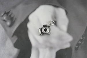 Macro detail of a vintage camera pendant with intricate lens and viewfinder textures