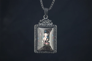 Detail view of Buddha pendant featuring retro silver frame and intricate religious artwork