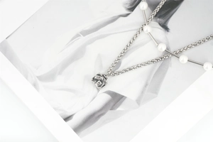 Detail of silver tone titanium necklace with pearls and vintage Paris square pendant