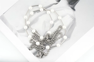 Detailed macro view of men's titanium steel chain necklace with pearls and Paris tag