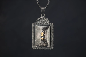 Macro detail of Buddhist deity pendant with retro cloud pattern and square box chain
