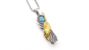 Detail of vintage turquoise feather pendant with gold and silver wings on link chain