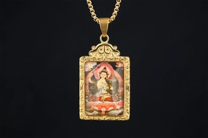 Macro shot of Thangka Buddha pendant with golden cloud patterns and colorful painting