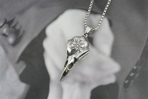 Gros plan du pendentif crâne de corbeau viking avec gravure Vegvisir et chaîne